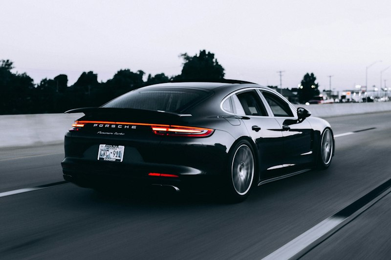 Modern sedan driving on open highway representing comprehensive collision coverage